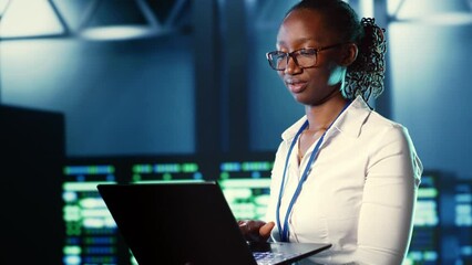 Poster - woman walking through high tech facility server rows providing computing resources for different wor
