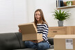 © New Africa - Emotional woman unpacking parcel at home. Online store