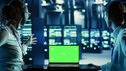Poster - it developers running code on green screen laptop, troubleshooting data center equipment. technician