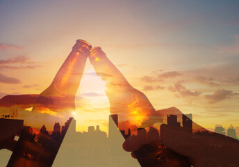 Wall Mural - Hands toasting beer on rooftop city sunset background. Party and celebration concept.