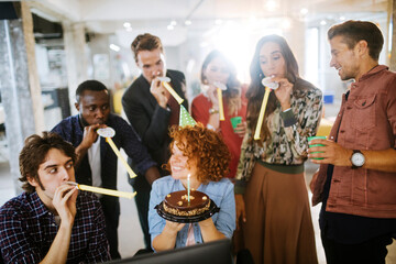 Wall Mural - Young and diverse group of people celebrating a surprise birthday party in the office of a startup company