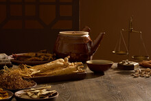 Scenes Of Many Oriental Medicines Are Displayed On A Wooden Background, Decorated With Medicine Pot, Bowl And A Small Ancient Scale. Background For Advertising With The Concept Of Folk Medicine