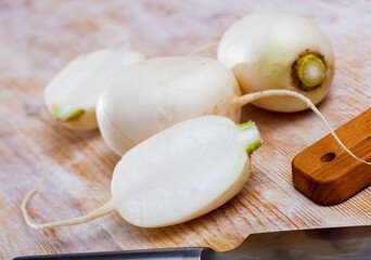 Wall Mural - Whole and cut in half ripe turnips root crops on wooden background. Healthy nutrition concept