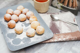 Fototapeta Tulipany - Curd donuts in powdered sugar on a plate, round donuts with a cup of tea