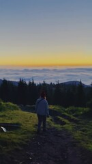 Wall Mural - girl walk on sunrise in the mountains, the Carpathians, Kukul ridge, rays of the sun, travel, landscapes, beauty of nature, grass, sea, river of clouds, above the sky, tourists on, hiking