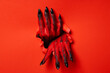 Leinwandbild Motiv Red female hands with black nails on red background
