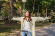 © MIND AND I - Happy woman riding bicycle at park.