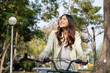 © MIND AND I - Happy woman riding bicycle at park.