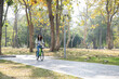© MIND AND I - Happy woman riding bicycle at park.