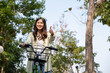 © MIND AND I - Happy woman riding bicycle at park.