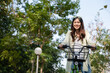 © MIND AND I - Happy woman riding bicycle at park.