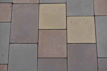 Wall Mural - Surface of pavement made of pink, yellow, brown and grey concrete blocks
