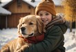A small child hugs his pet golden retriever. Winter activity holidays.