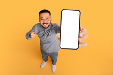 Aufkleber - Check This. Smiling Asian Man Pointing At Big Blank Smartphone In Hand