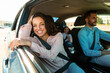 © Prostock-studio - Happy family in car, woman smiling to camera sitting on passenger seat, enjoying trip by their new auto