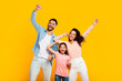 © Prostock-studio - Victory concept. Overjoyed european family of three shaking clenched fists, making winner gesture over yellow background