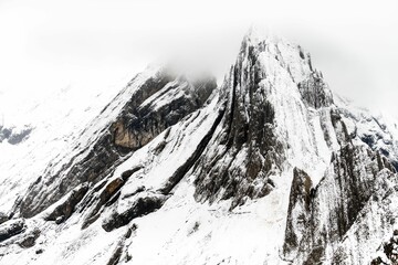 Wall Mural - Snow-covered peaks and mountains on a misty day