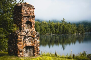 Sticker - Old chimney next to a lake in the forest, with fog over the trees