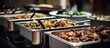 Several savory entrees are served in chafer dishes at a catered event with guests helping themselves