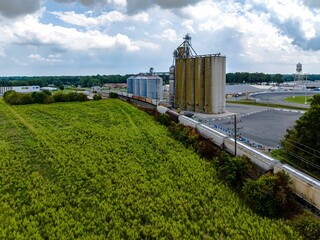 Poster - Aerial view of a long cargo train near a farm in Delaware on a sunny day