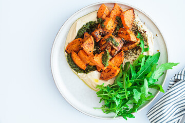 Canvas Print - Vegan lunch - hummus, baked sweet potato and pesto, white background.