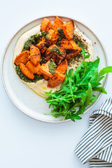 Wall Mural - Vegan lunch - hummus, baked sweet potato and pesto, white background.