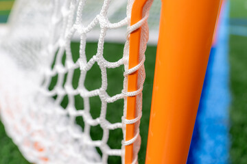 Wall Mural - Photo of a lacrosse goal on a empty green synthetic turf field.	