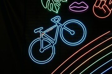 Wall Mural - Illuminated neon sign with a bicycle silhouette displayed on a black wall at a cafe at night