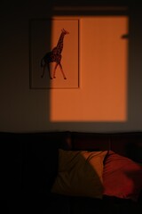 Canvas Print - Window casting a silhouette on a giraffe picture hanging from the wall