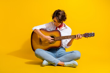 Sticker - Photo of adorable lovely girl wear stylish outfit sitting floor learning play guitar isolated on yellow color background