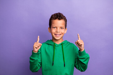 Wall Mural - Photo of funky excited little boy dressed green hoodie showing two fingers up empty space isolated purple color background