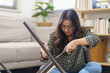 Asian Woman self repairs furniture renovation using equipment to diy repairing furniture sitting on the floor at home