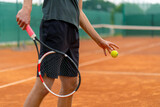 Fototapeta Sport - young professional player coach on outdoor tennis court practices strokes with racket and tennis ball