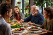 © Bojan - Happy multi-generation family gathering around dining table talking during a lunch.