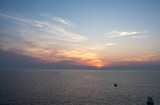 Fototapeta Nowy Jork - Sun halfway set on the horizon on a cape cod bay beach