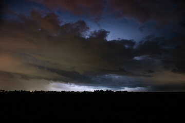 Wall Mural - menacing stormy sky is made visible by lightning in the background