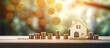 Saving funds for purchasing a house by creating a miniature home with coins on a wooden table against a backdrop of a tree and bokeh lights