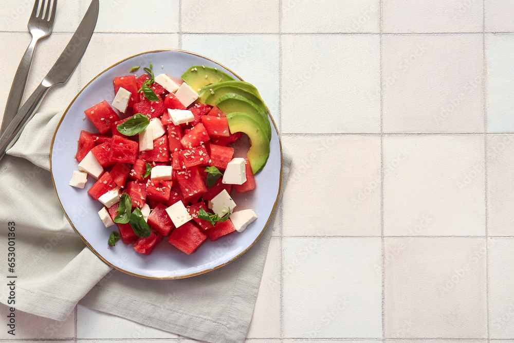 Plate of tasty watermelon salad on white tile background