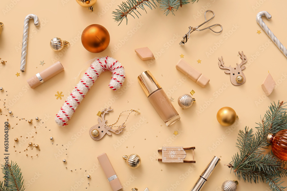 Decorative cosmetics with fir tree branches and Christmas decor on beige background