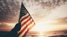 Waving Usa Flag In Hand At Sunset