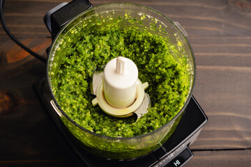 Wall Mural - Freshly Mixed Pesto in a Small Food Processor: Italian pesto sauce ingredients including basil and olive oil blended in a mini-prep