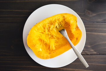 Sticker - Shredding a Spaghetti Squash with a Fork: Seeded and cooked half of spaghetti squash being shredded with a fork