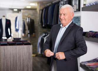 Mature male shopper shows off his jacket at a men's store