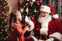 Photo Of A Little Girl Standing Next To Santa Claus