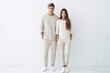 A young couple poses on a white background, wearing white casual clothes, models posing.