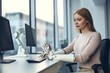 A woman works in her office, assisted by a robotic prosthetic arm.