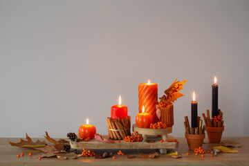 Poster - autumn decor with burning candles on wooden shelf