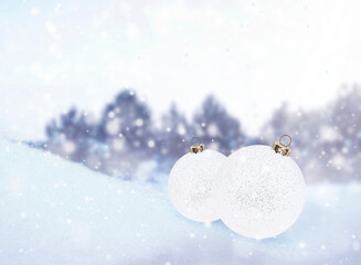 Wall Mural - two white christmas ornaments on the snow against the background of a winter forest