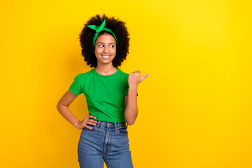 Canvas Print - Portrait of lovely positive person beaming smile look indicate finger empty space offer isolated on yellow color background