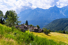 Idyllic Alpine Village On A Green Slope With An Mountainous Background, Varzo, The Valley Of Ossola, Piedmont, Italy